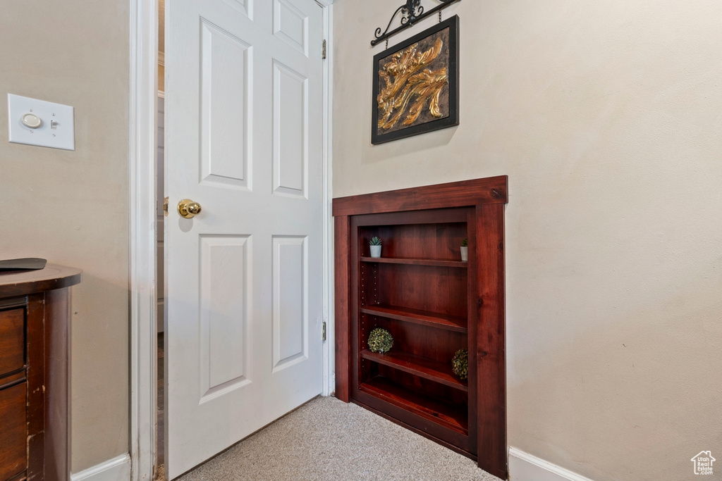 Corridor featuring carpet floors and baseboards