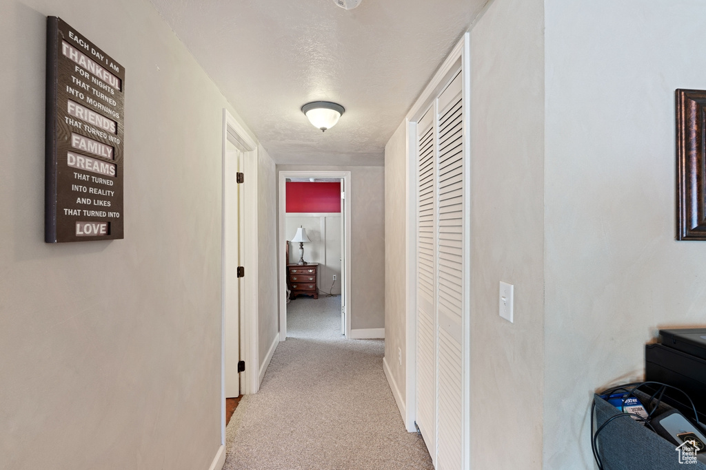 Hall with carpet flooring and baseboards