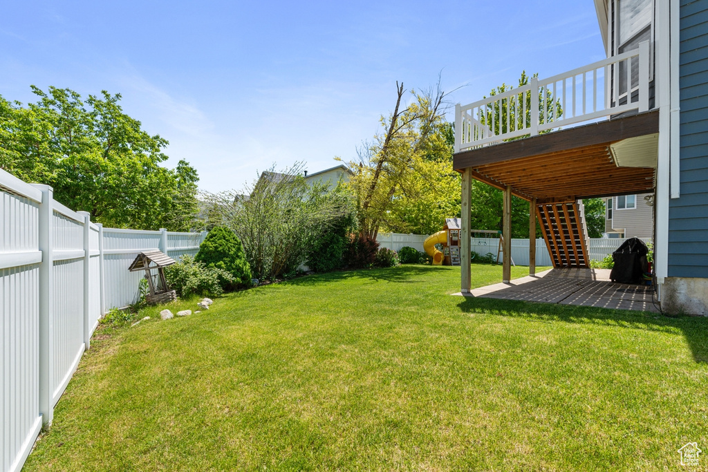 View of yard featuring a deck, stairs, and a patio