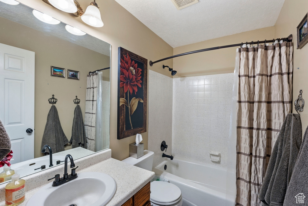 Full bath with vanity, toilet, and shower / tub combo with curtain