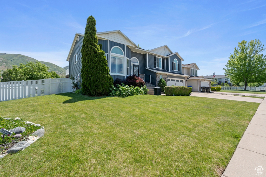 View of front of property with concrete driveway, an attached garage, and a mountain view