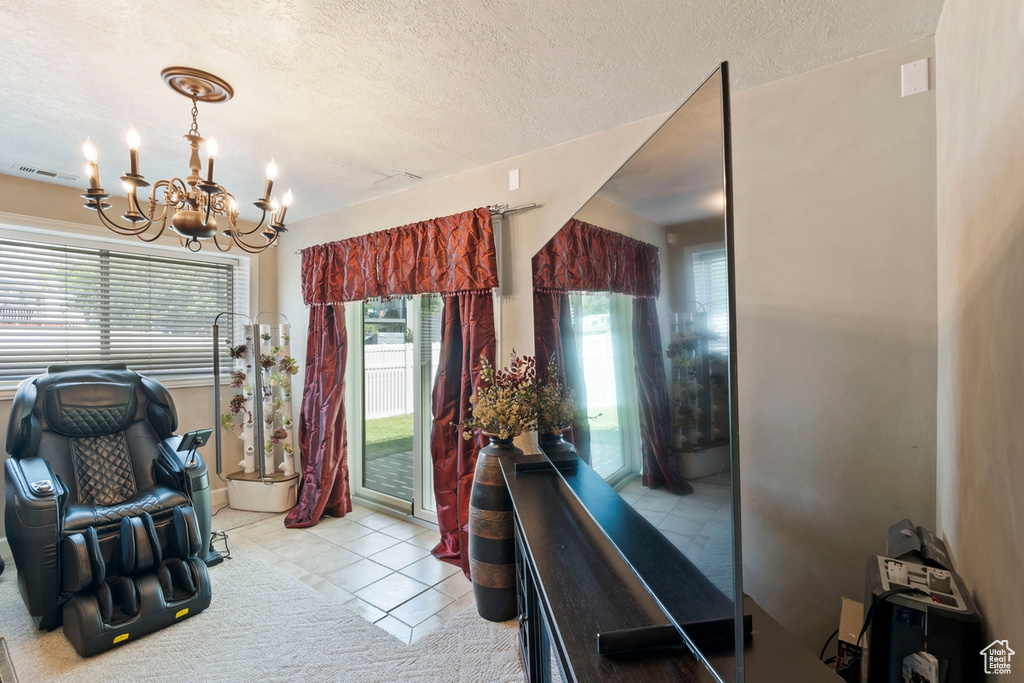 Interior space featuring a chandelier, a textured ceiling, and light tile patterned floors
