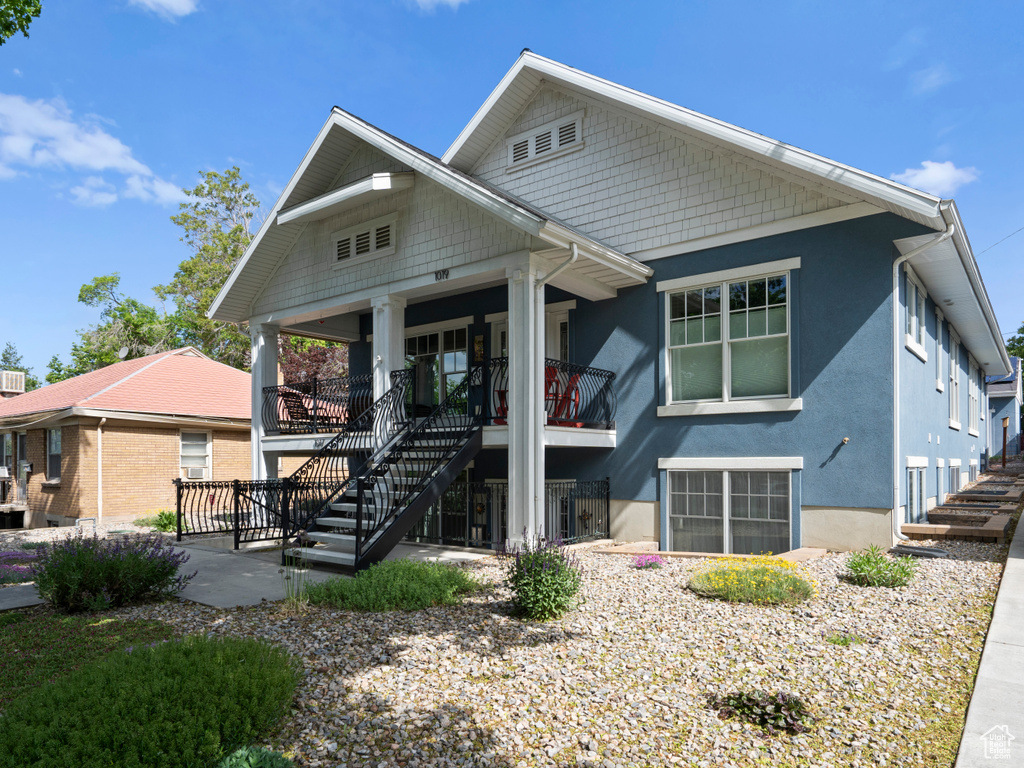 View of front of home featuring stairs, stucco siding, and a porch