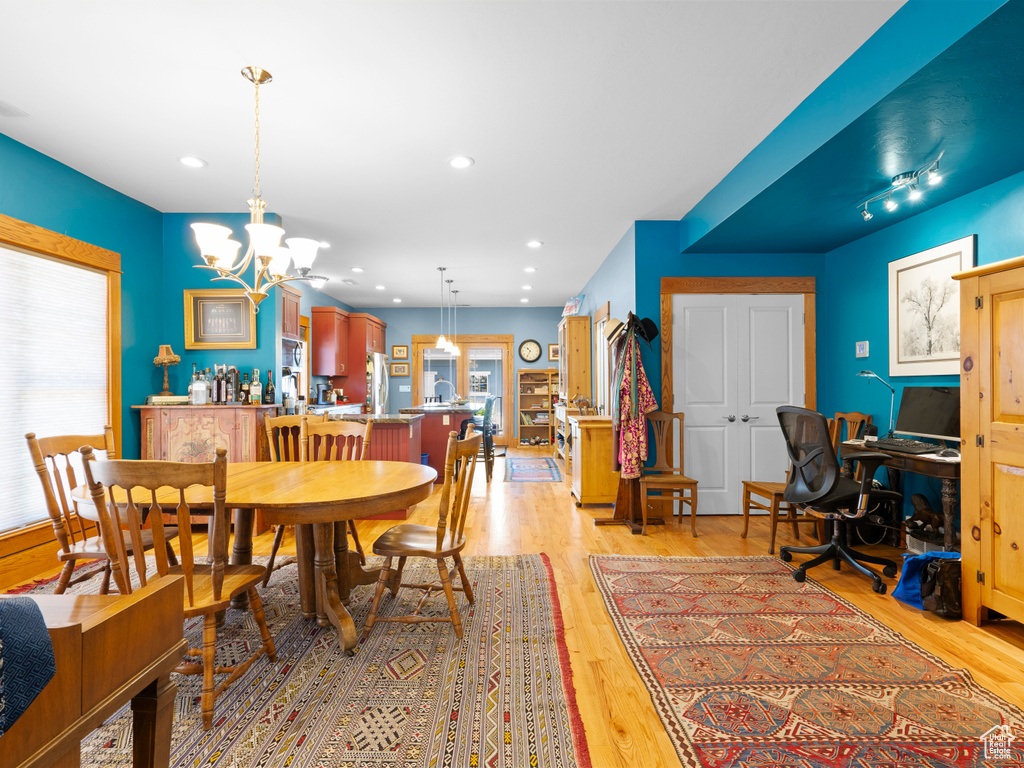 Dining room featuring plenty of natural light, light wood-style flooring, a chandelier, and recessed lighting