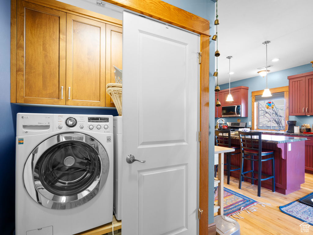 Washroom with washer / dryer, cabinet space, light wood-type flooring, and recessed lighting