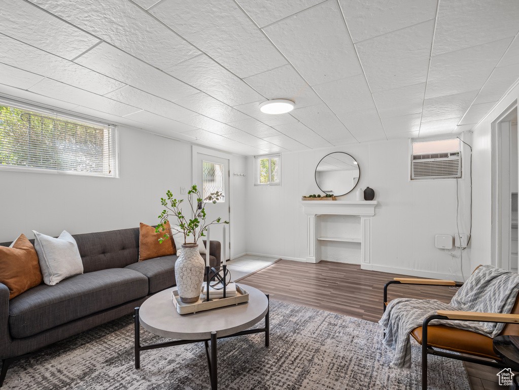 Living area with wood finished floors and a wall mounted air conditioner