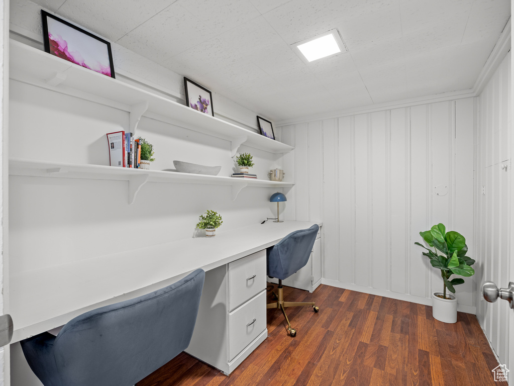 Office area featuring built in desk and dark wood finished floors