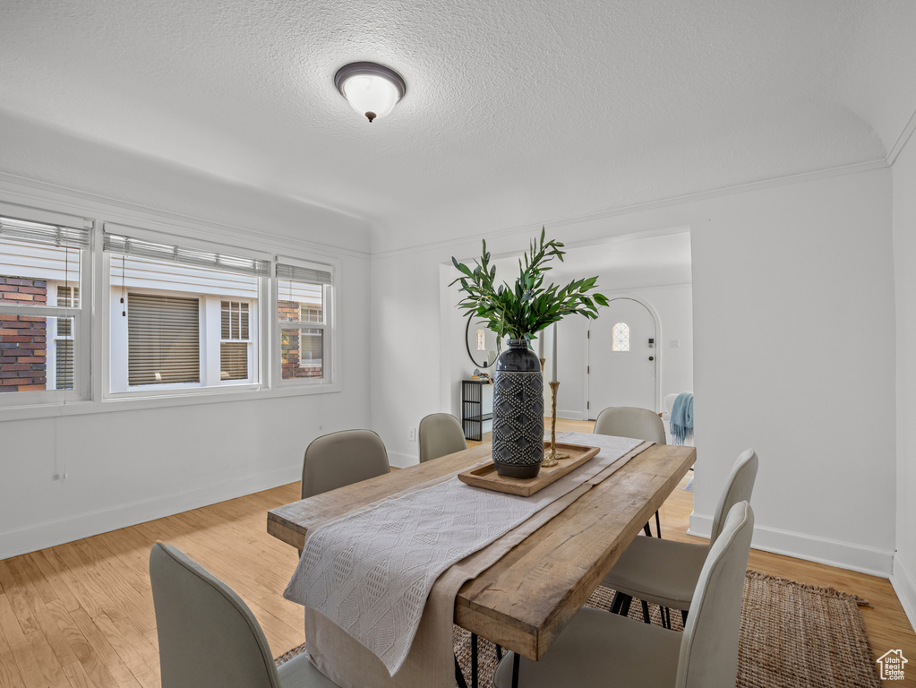 Dining space with light wood-style flooring and a textured ceiling