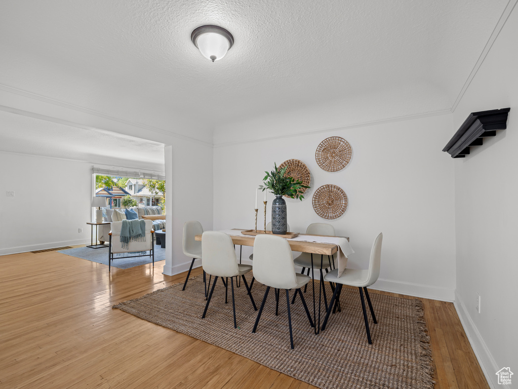 Dining space with wood finished floors and a textured ceiling