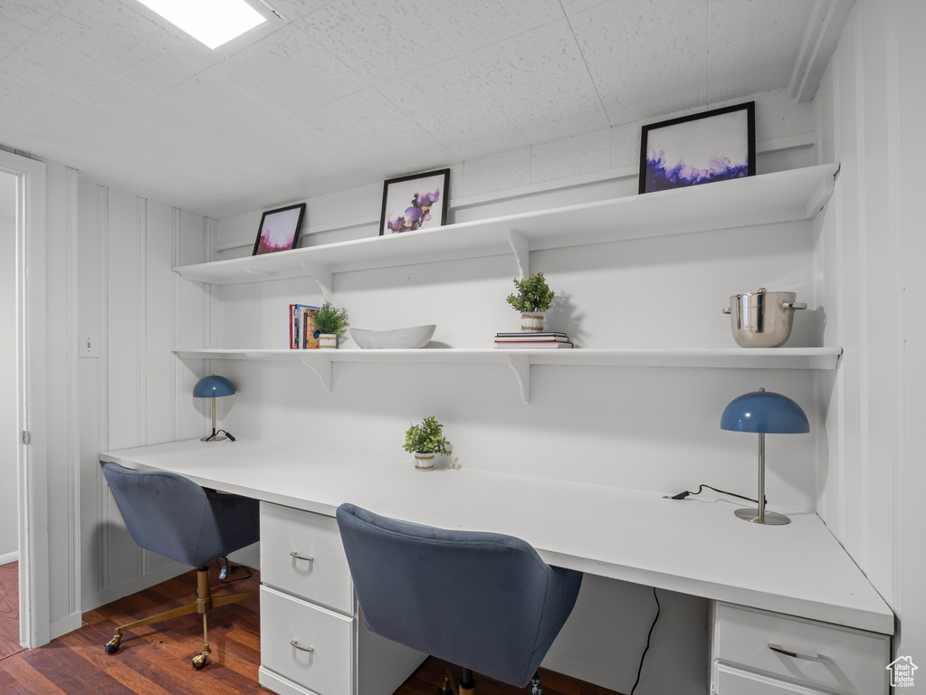 Office space featuring built in study area and dark wood-style floors