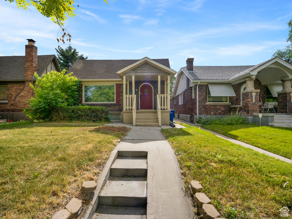 View of front of property featuring a front yard and brick siding