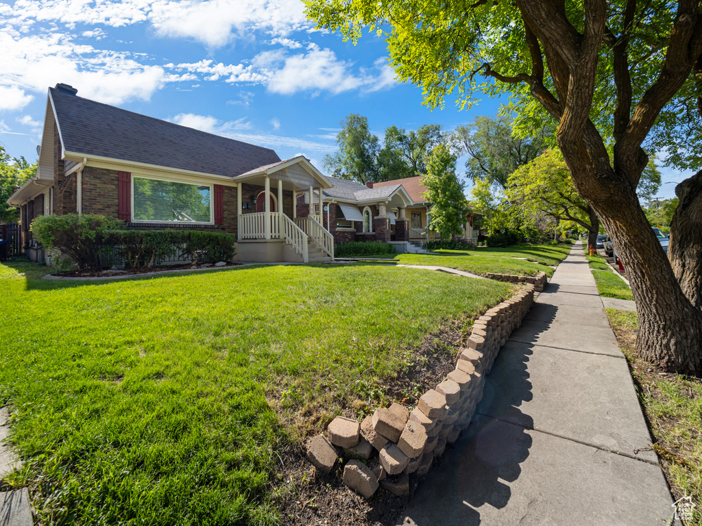 Single story home with brick siding, a front lawn, and a shingled roof