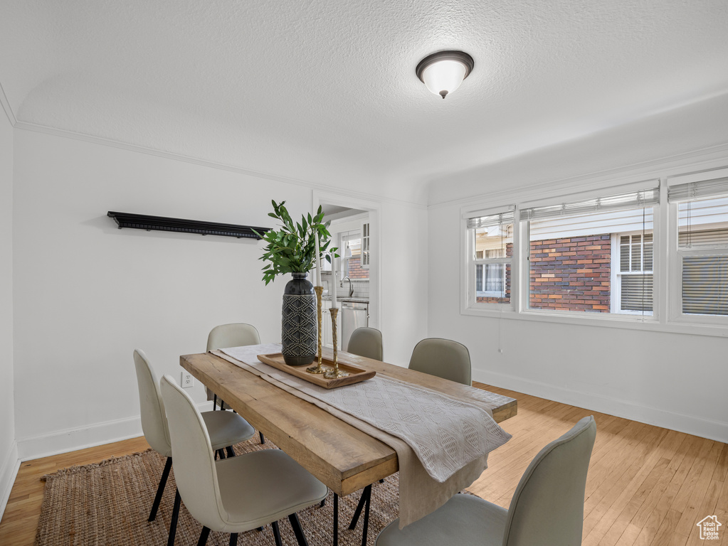 Dining area with light wood-style floors and a textured ceiling