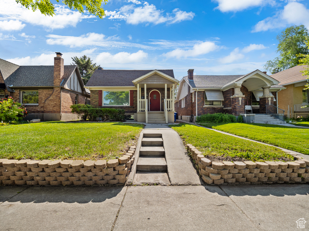 View of front facade featuring brick siding and a front yard