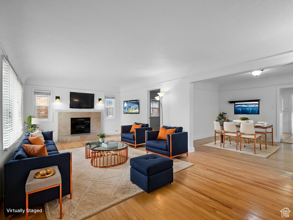 Living area with wood finished floors and a tile fireplace