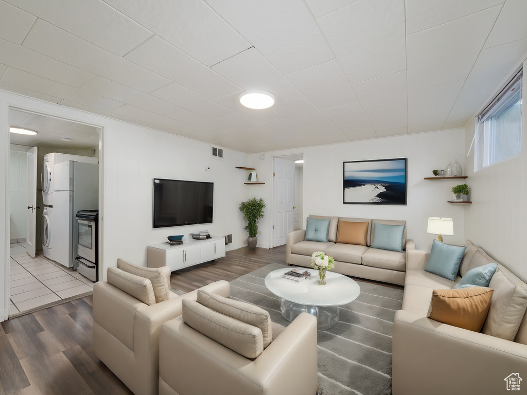 Living room featuring stacked washer / dryer and wood finished floors