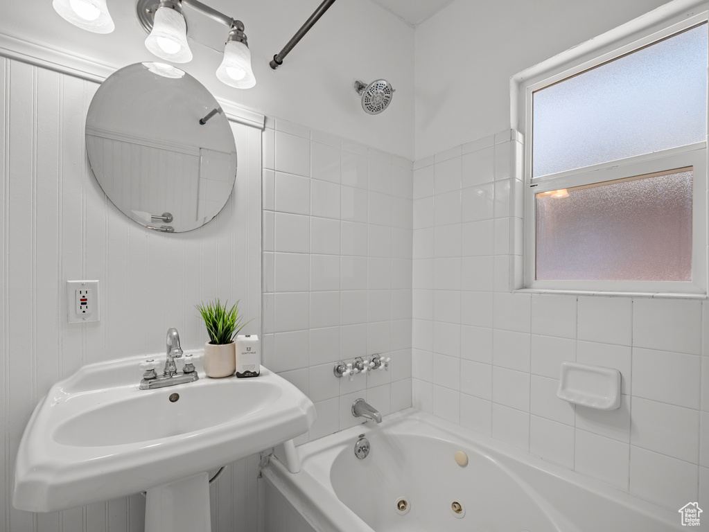 Bathroom featuring a combined bath / shower with jetted tub and a sink