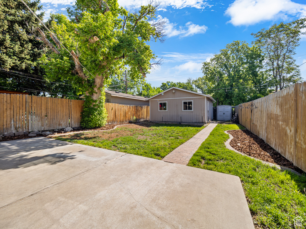 View of yard featuring a patio and an outbuilding