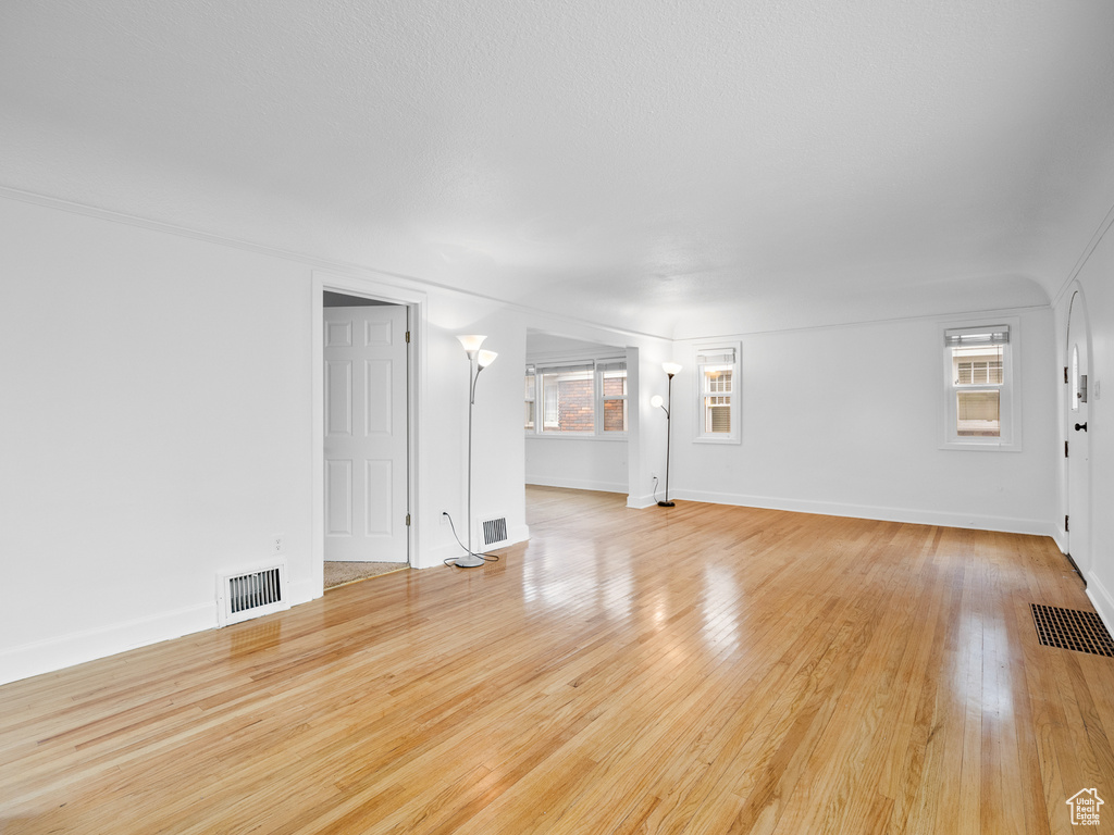 Unfurnished living room with light wood-style floors and baseboards