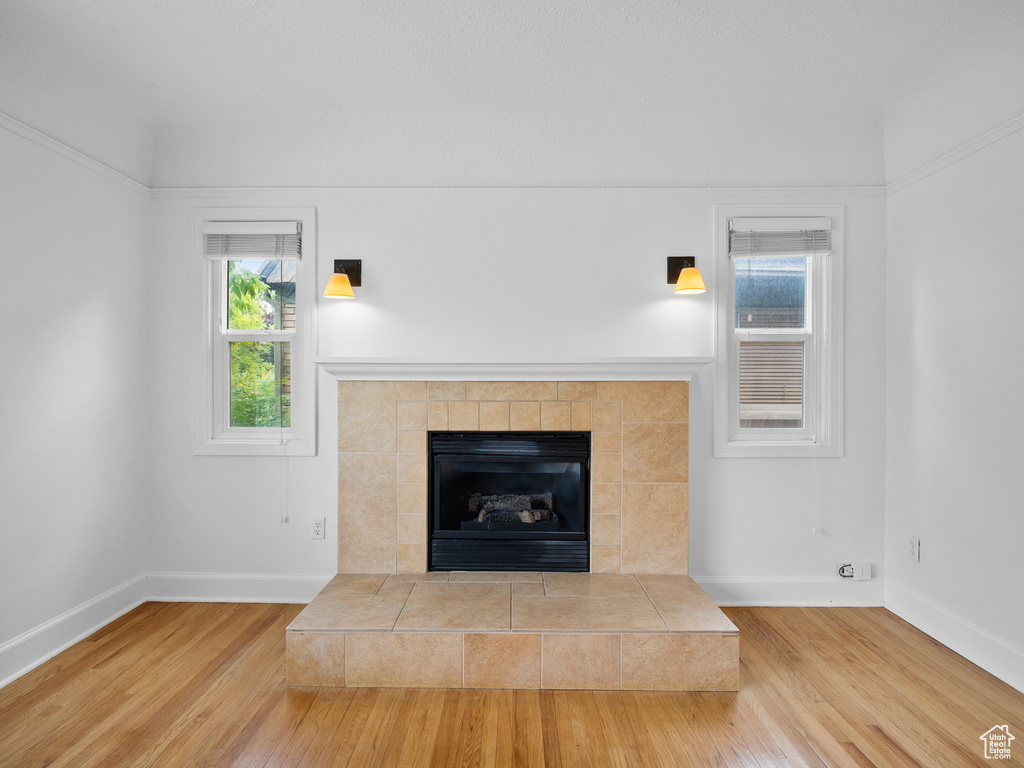 Detailed view of wood finished floors, baseboards, and a tiled fireplace