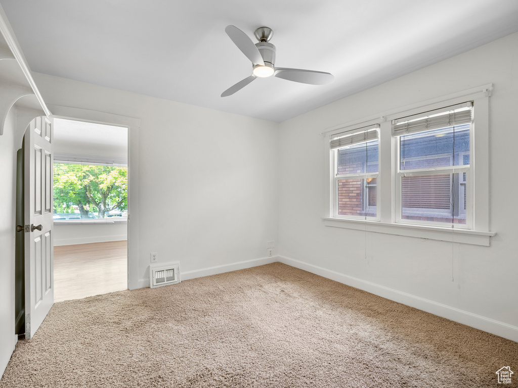 Spare room featuring carpet, ceiling fan, and baseboards