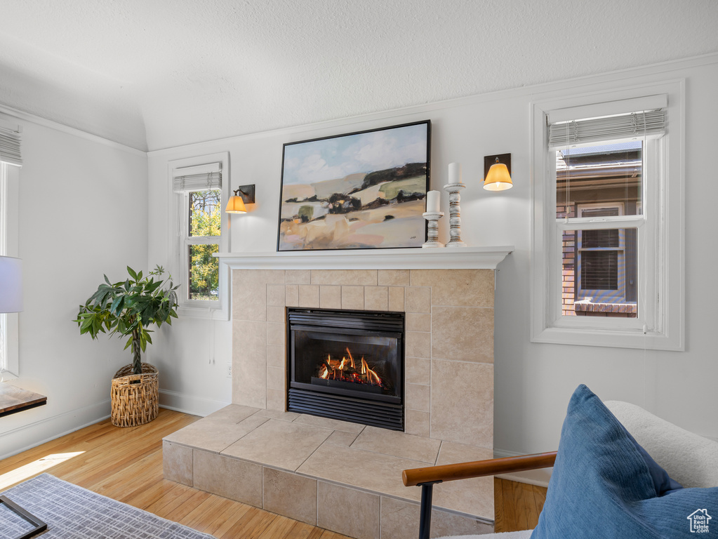 Living area with a tiled fireplace and wood finished floors