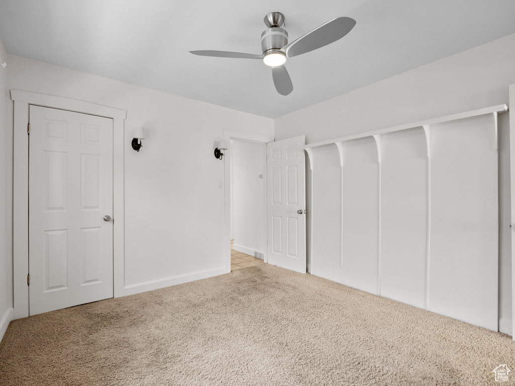 Unfurnished bedroom featuring carpet flooring, a closet, ceiling fan, and baseboards