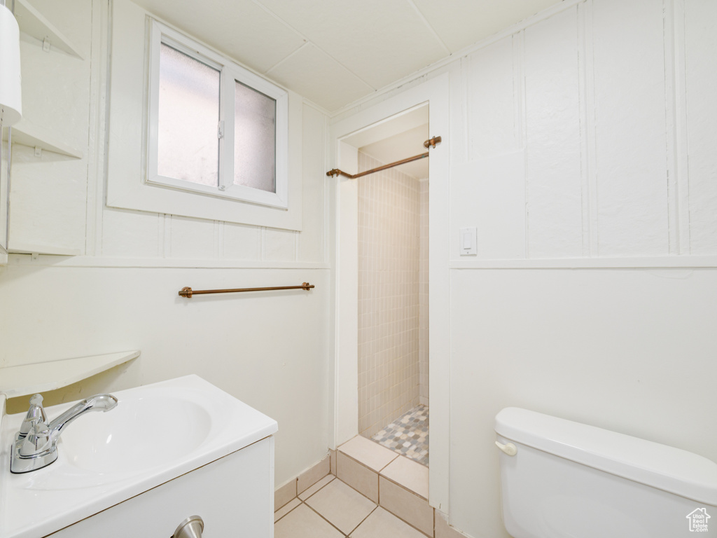 Full bathroom with a stall shower, toilet, tile patterned floors, and vanity