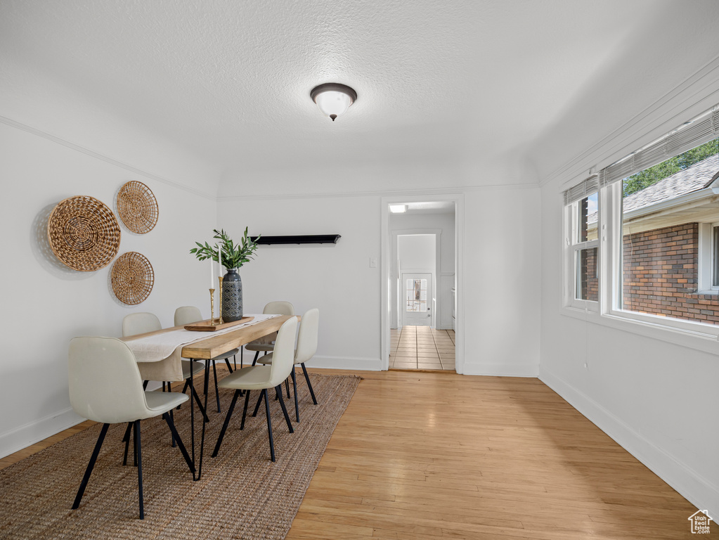 Dining area featuring light wood finished floors and a textured ceiling