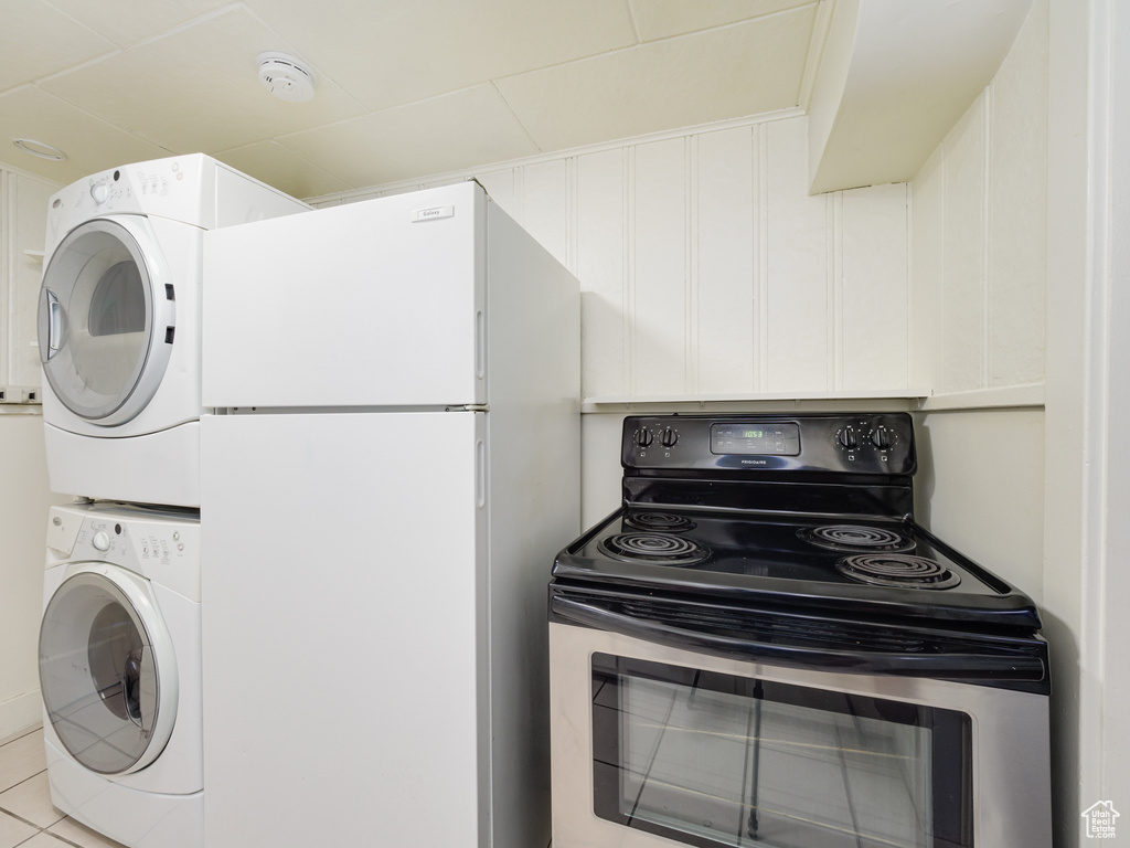 Laundry room featuring stacked washer / dryer and tile patterned floors