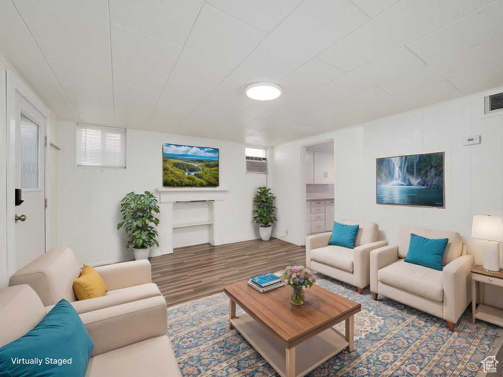 Living area with wood finished floors and a wall mounted air conditioner