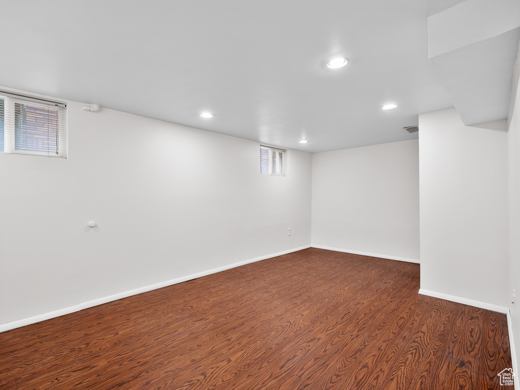 Below grade area with dark wood-style floors, recessed lighting, and baseboards