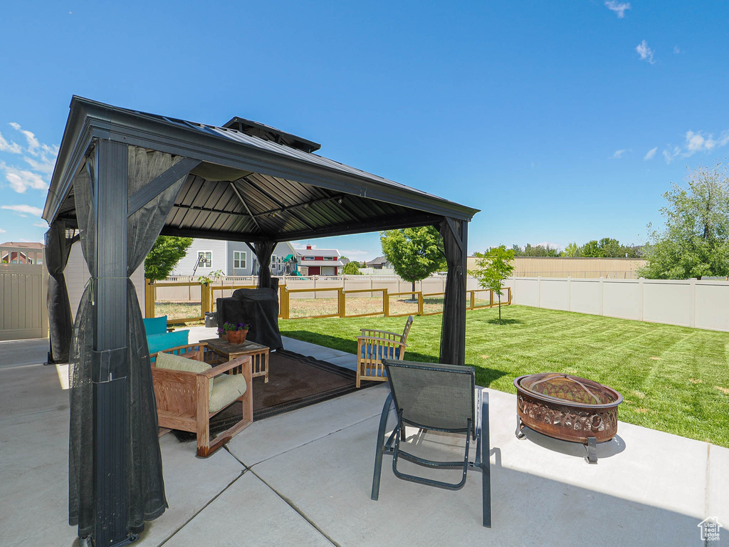 View of patio featuring an outdoor fire pit and a gazebo