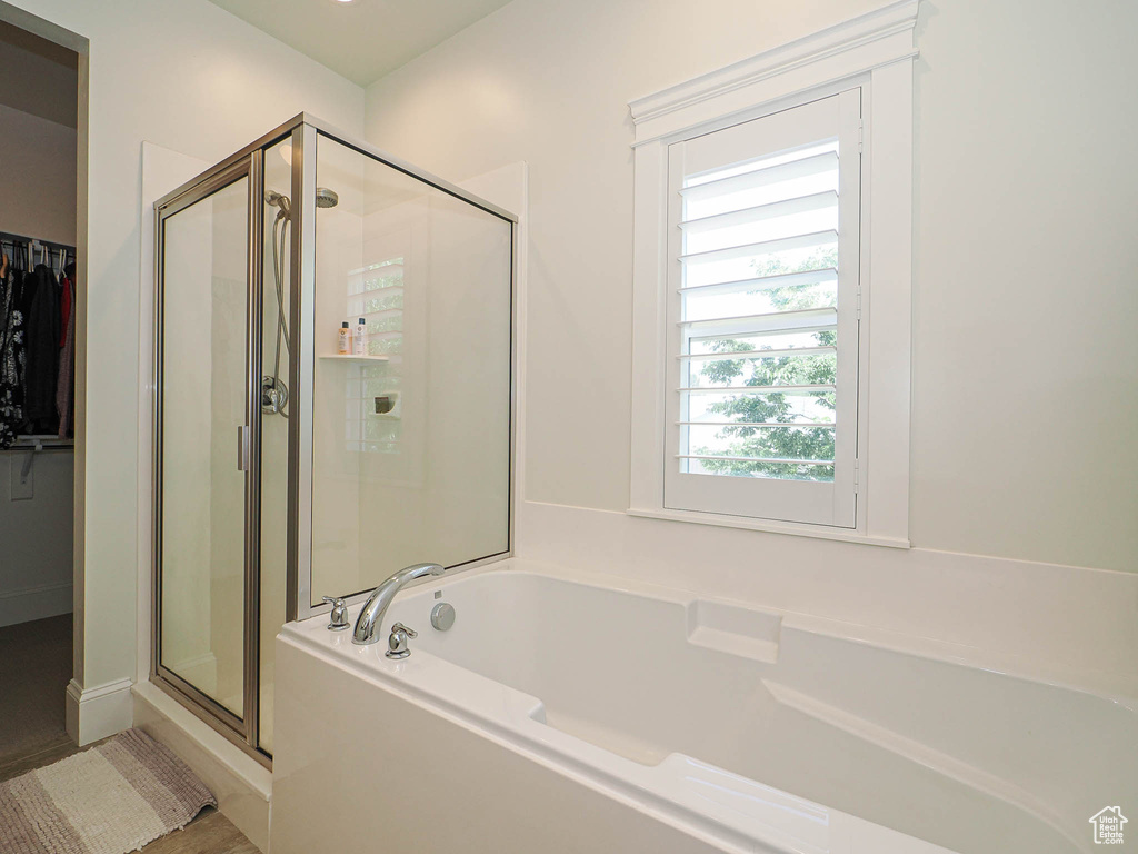 Full bathroom with a stall shower, a garden tub, and a spacious closet