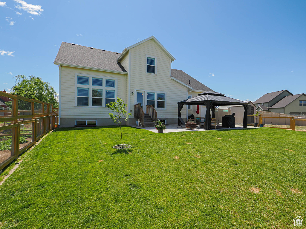 Rear view of house with a gazebo, a patio area, and roof with shingles