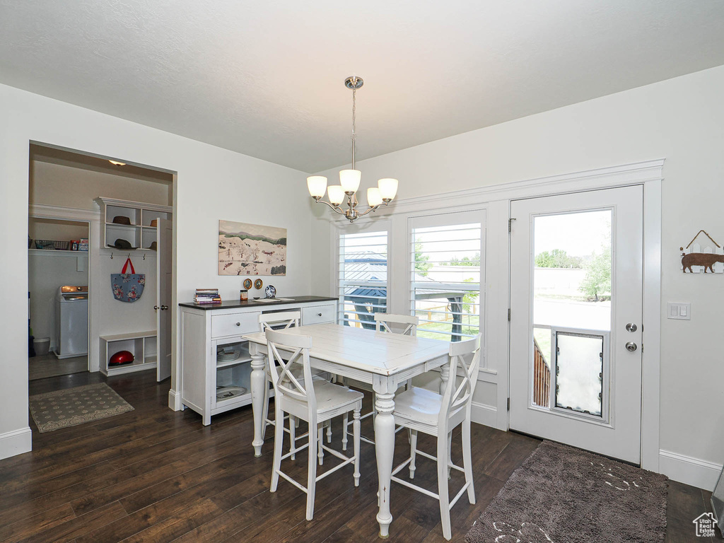 Dining area featuring a chandelier, dark wood-style flooring, and baseboards