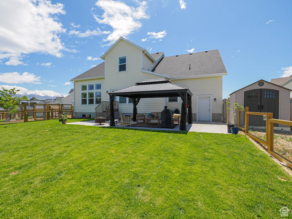 Rear view of property featuring a gazebo, a patio area, and a shingled roof
