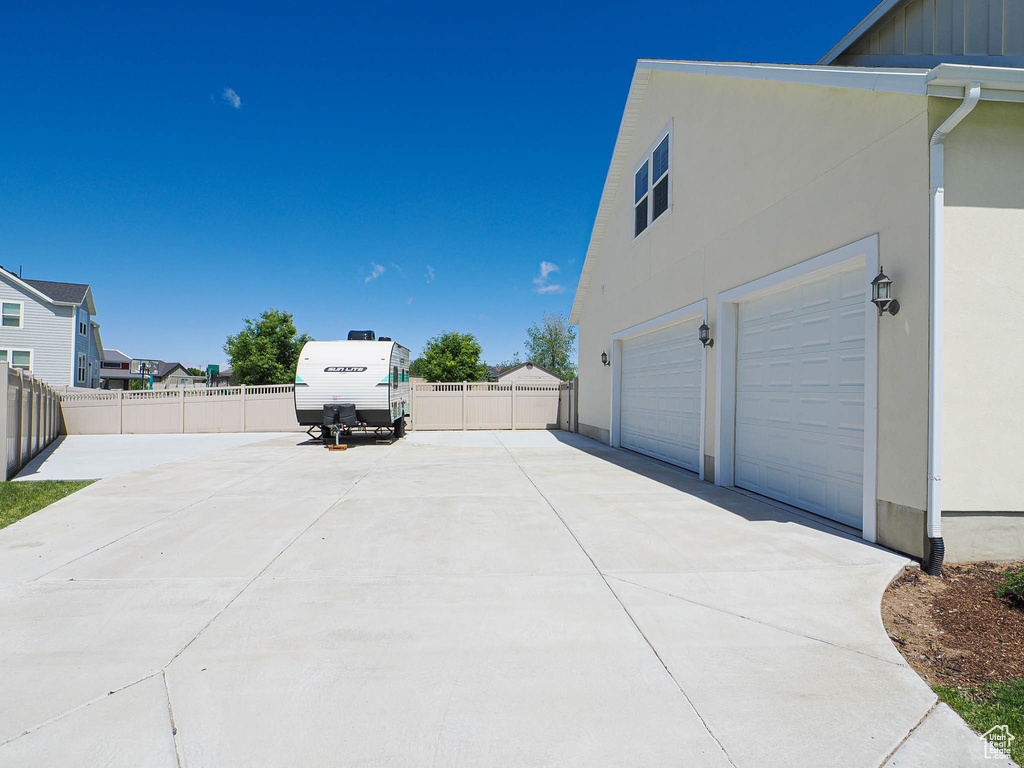 View of home\\\'s exterior featuring driveway, stucco siding, a garage, and board and batten siding