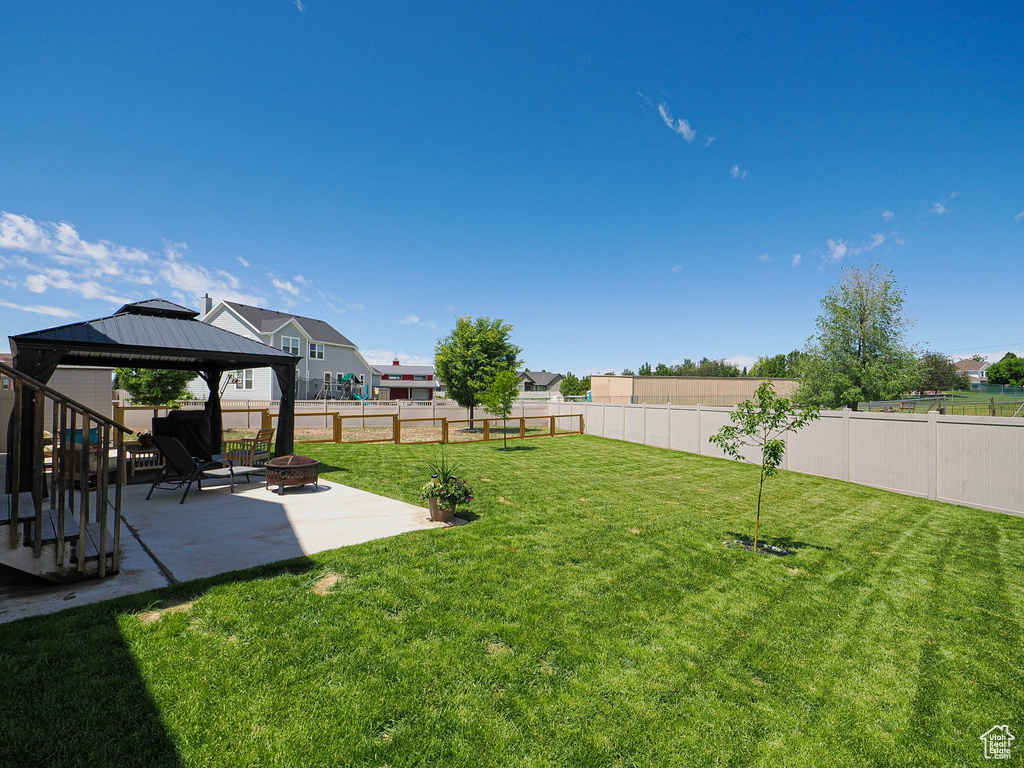 View of yard featuring a patio area, an outdoor fire pit, and a gazebo