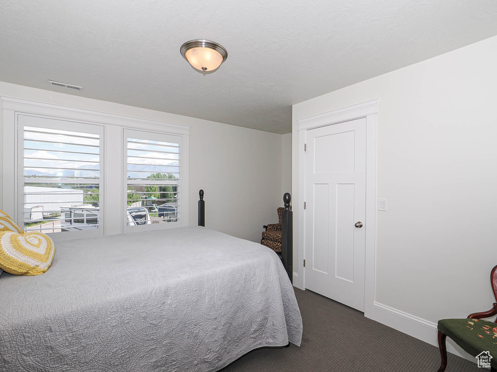 Bedroom with dark carpet and baseboards