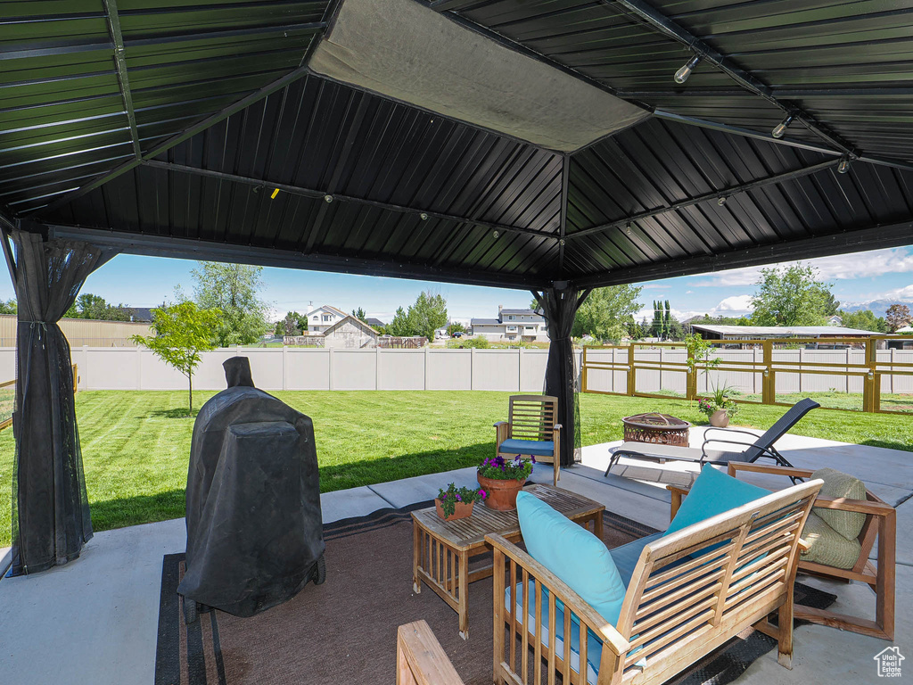 View of patio featuring a fire pit, grilling area, and a gazebo