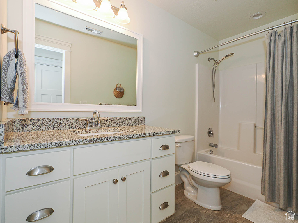 Bathroom with vanity, toilet, and shower / bath combo