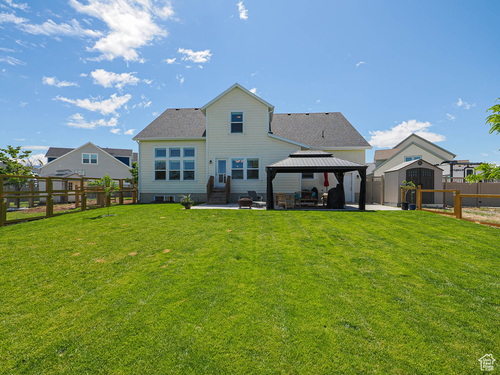 Back of property featuring a gazebo, a patio area, and roof with shingles