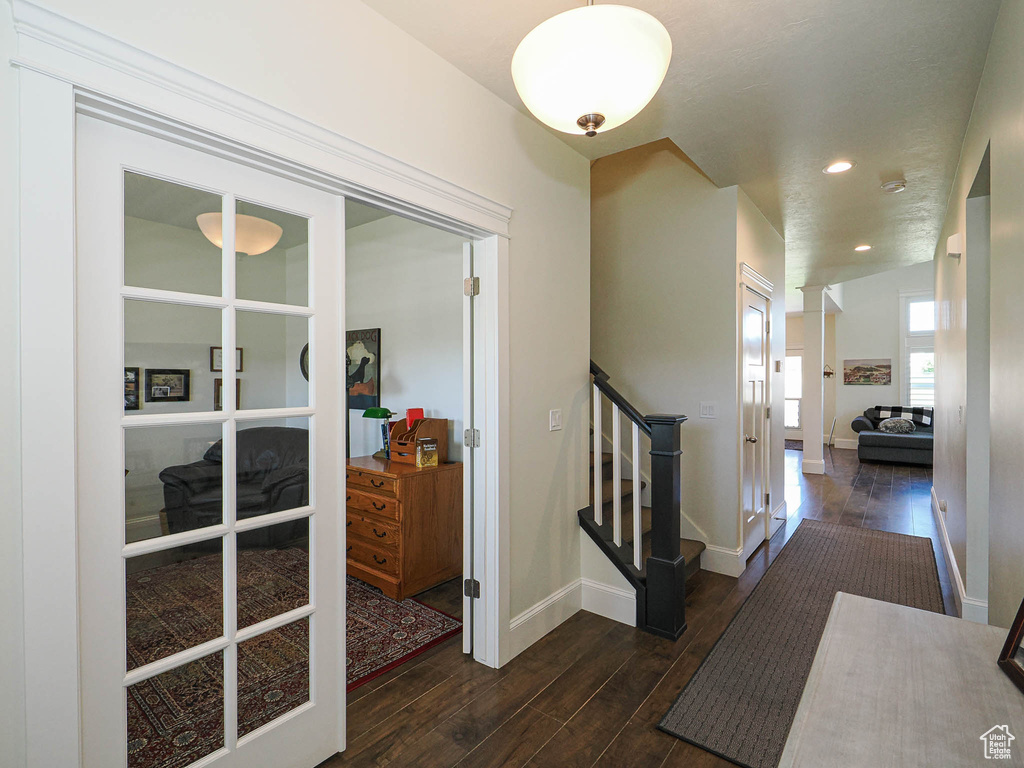 Hallway featuring wood finished floors, baseboards, stairs, and recessed lighting
