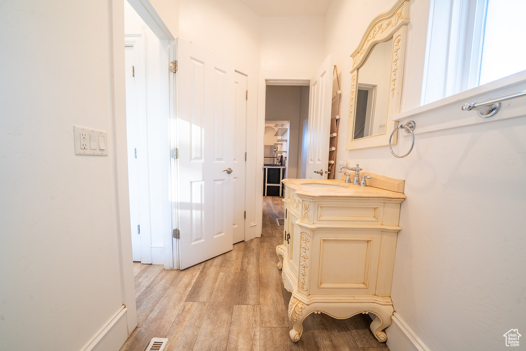 Hallway featuring a sink and light wood-style floors