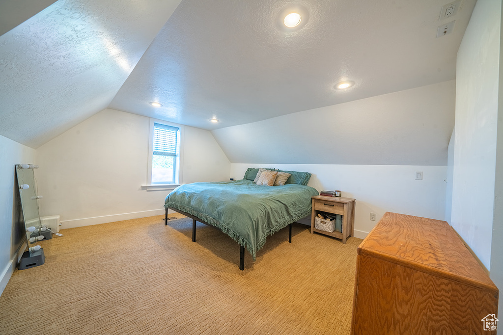 Bedroom featuring lofted ceiling, light colored carpet, baseboards, recessed lighting, and a textured ceiling