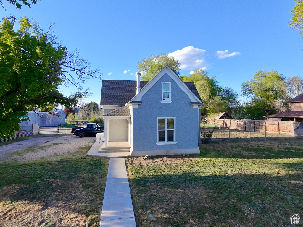 View of front facade featuring a shingled roof and stucco siding