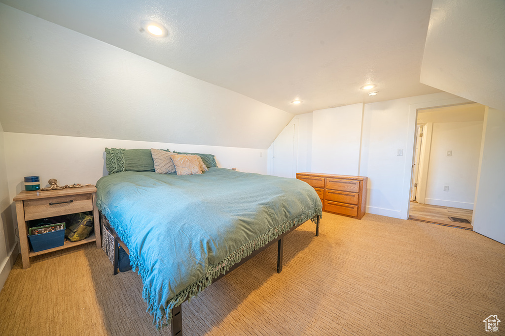 Bedroom featuring vaulted ceiling, recessed lighting, light carpet, and baseboards