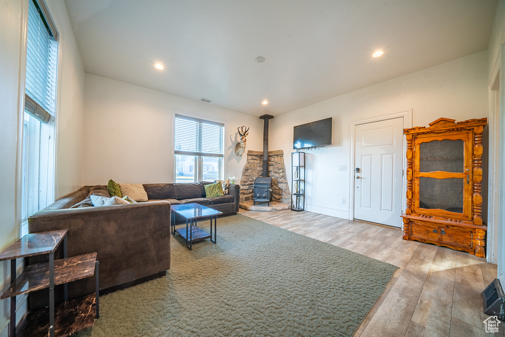 Living area featuring a wood stove, wood finished floors, and recessed lighting