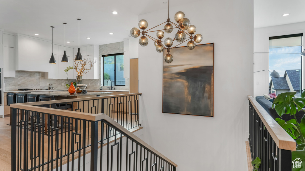 Stairs with recessed lighting and a chandelier